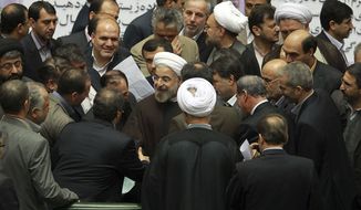 In this photo released by the official website of the office of the Iranian Presidency, Iran&#39;s President Hassan Rouhani, center, is surrounded by lawmakers during an open session of parliament to submit next year&#39;s budget bill, in Tehran, Iran, Sunday, Dec. 8, 2013. Rouhani said Sunday that last month&#39;s nuclear deal with world powers has already boosted the country&#39;s economy, as he continues a push to convince skeptics of the benefits brought by the pact&#39;s partial sanctions relief.  The proposed budget covers Iran&#39;s fiscal year that starts March 21, 2014. (AP Photo/Presidency Office, Rouzbeh Jadidoleslam)