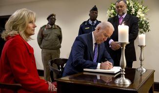 Vice President Joe Biden, accompanied by his wife Jill, signs a condolence book inside the South African Embassy in Washington, Monday, Dec. 9, 2013, as they paid their respects to former South African President Nelson Mandela. (AP Photo/Jacquelyn Martin)
