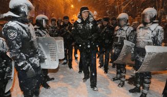Ukrainian lawmaker and chairman of the opposition party Udar (Punch), WBC heavyweight boxing champion Vitali Klitschko surrounded by police trying to stop possible clashes between police and Pro-European Union activists in Kiev, Ukraine, Monday, Dec. 9, 2013. Hundreds of police in full riot gear on Monday flooded the center of Kiev key sites of mass anti-government protests that have gripped the capital for weeks, raising fears of a crackdown.(AP Photo/Efrem Lukatsky)