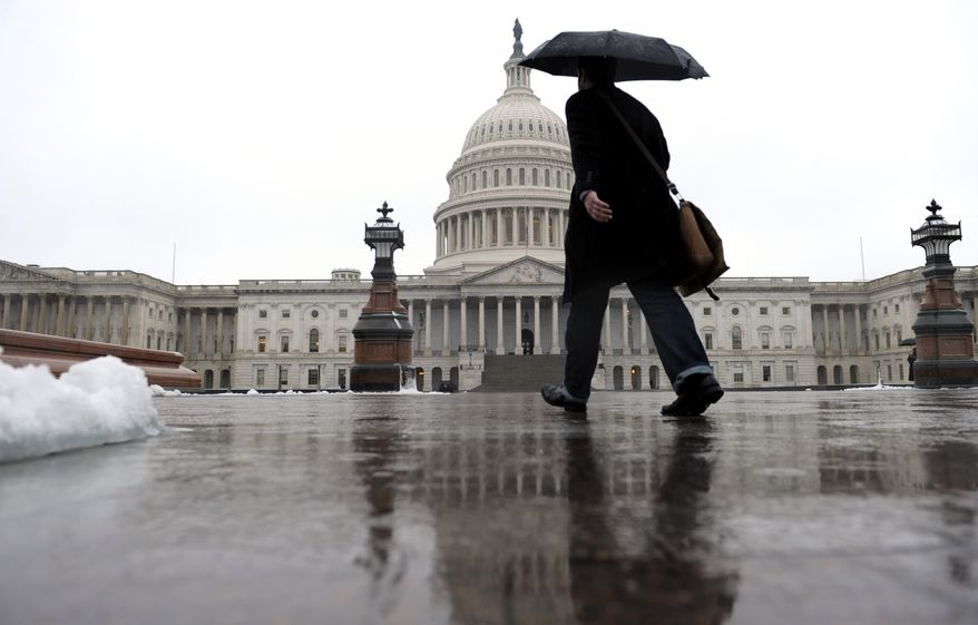 A person walks on Capitol Hill in Washington, Monday, Dec. 9, 2013, as rain, snow, sleet and freezing rain affected most of the U.S. Mid-Atlantic region on Sunday and into Monday. (AP Photo/Susan Walsh)