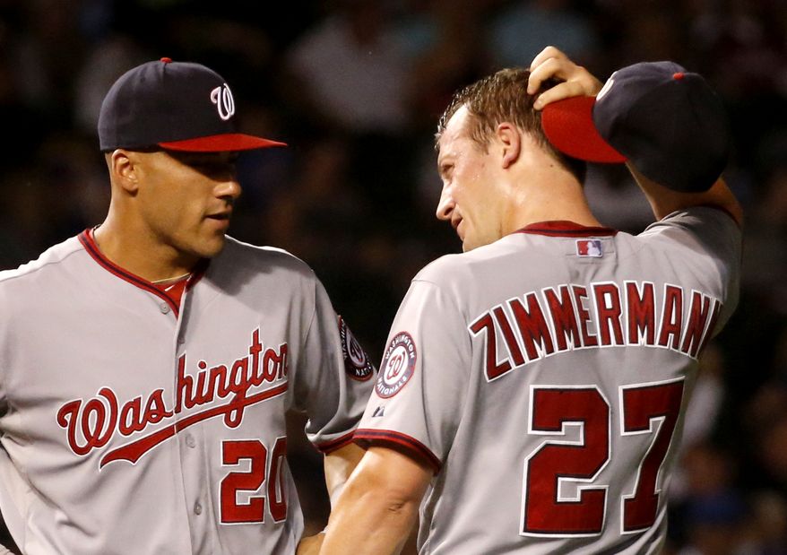 Washington Nationals starting pitcher Jordan Zimmermann (27) scratches his head as he talks with shortstop Ian Desmond during the fifth inning of a baseball game against the Chicago Cubs, Monday, Aug. 19, 2013, in Chicago. Shortly after the conversation Zimmermann gave up a three-run home run to the Cubs' Dioner Navarro. (AP Photo/Charles Rex Arbogast)
