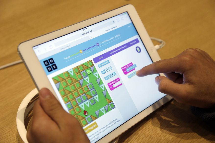 Matthew Triska, 13, learns to build code using an iPad at a youth workshop at the Apple store on Wednesday, Dec. 11, 2013, in Stanford, Calif. Apple stores nationwide were participating in computer science education week Wednesday, part of a joint effort with code.org to teach children the basics of coding. (AP Photo/Marcio Jose Sanchez)