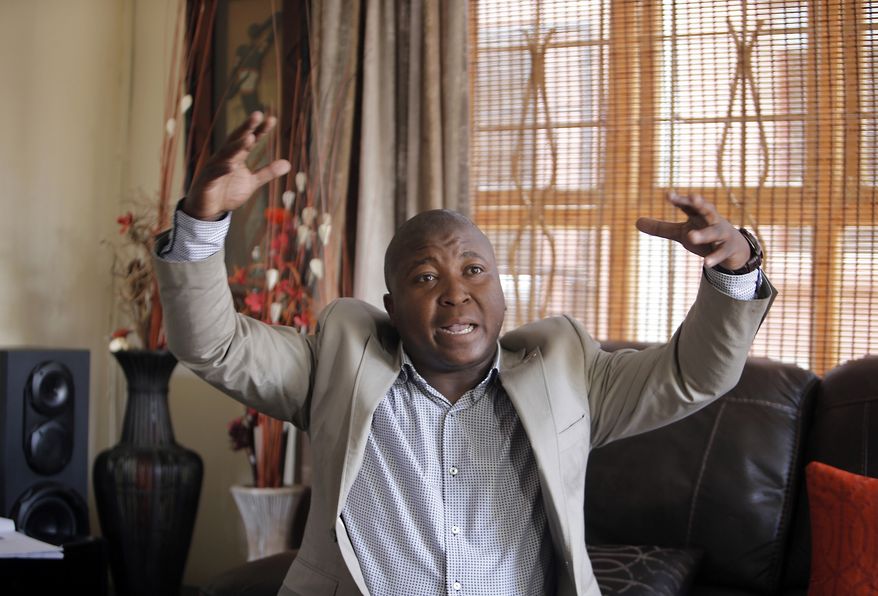 Thamsanqa Jantjie gesticulates at his home during an interview with the Associated Press in Johannesburg, South Africa,Thursday, Dec. 12, 2013. Jantjie, the man accused of faking sign interpretation next to world leaders at Nelson Mandela's memorial, told a local newspaper that he was hallucinating and hearing voices. (AP Photo/Tsvangirayi Mukwazhi)