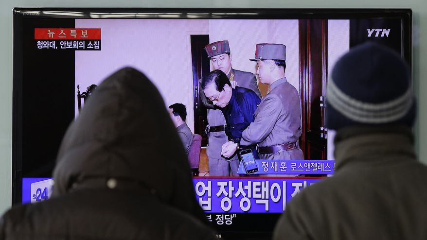 People watch a live TV news program showing that North Korean leader Kim Jong Un's uncle Jang Song Thaek, second from right, is escorted by military officers during a trial in Pyongyang, North Korea Thursday, Dec. 12, 2013, at the Seoul Railway Station in Seoul, South Korea, Friday, Dec. 13, 2013. North Korea said Friday that it had executed Jang as a traitor for trying to seize supreme power, a stunning end for the leader's former mentor, long considered the country's No. 2 official. The letters on the left top, read "North Korea Executed Jang Song Thaek after trial." (AP Photo/Lee Jin-man)