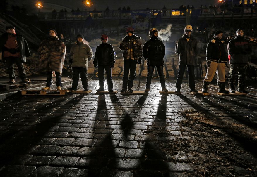 Pro-European Union activists guard barricades near the Independence Square in Kiev, Ukraine, early Friday, Dec. 13, 2013. Ukraine was thrown into crisis last month when President Viktor Yanukovych suddenly backed away from a long-awaited political and economic agreement with the European Union, deciding to focus instead on restoring trade ties with Russia. (AP Photo/Dmitry Lovetsky)