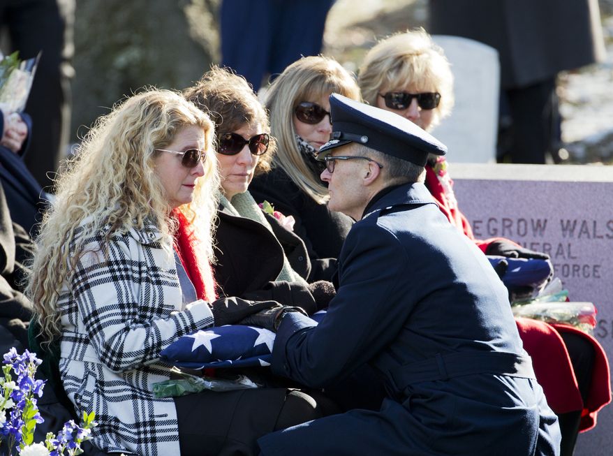 Maj. Gen. Steven Lepper, front right, consoles the family of U.S. Air Force Col. Francis McGouldrick Jr., from left, Marri Petrucci, Melisa Hill, Megan Genheimer, Michele Guess, as he hands each one of them an American flag during burial services at Arlington National Cemetery in Arlington, Va., Friday, Dec. 13, 2013. Col. McGouldrick from New Haven, Conn., was laid to rest 45 years after he was reported missing during the Vietnam War. The Pentagon says Col. McGouldrick crashed in Laos during a mission on Dec. 13, 1968. (AP Photo/Manuel Balce Ceneta)