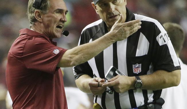 Washington Redskins head coach Mike Shanahan speaks with official Mike Weatherford during the first half of an NFL football game against the Atlanta Falcons, Sunday, Dec. 15, 2013, in Atlanta. (AP Photo/David Goldman)