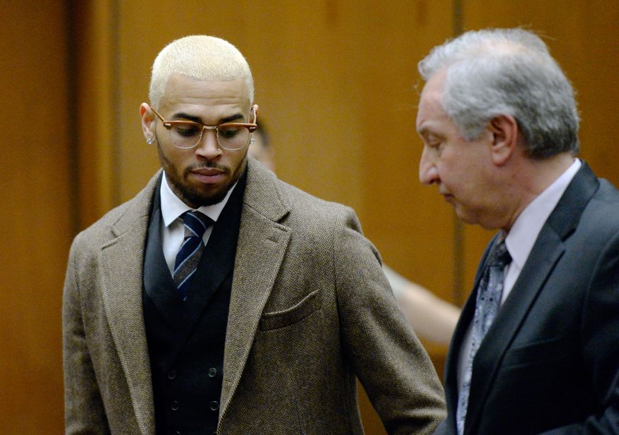 R&B singer Chris Brown, left, appears in court with his attorney Mark Geragos during a probation violation hearing in which his probation was revoked by a Los Angeles Superior judge, Monday, Dec. 16, 2013, in Los Angeles. Superior Court Judge James R. Brandlin revoked Brown's probation after his recent arrest on suspicion of misdemeanor assault in Washington, D.C., but the ruling will not alter the singer's requirements to complete rehab and community labor for his 2009 attack on Rihanna. (AP Photo/Kevork Djansezian, Pool)