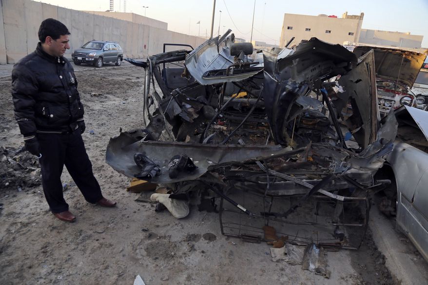 An Iraqi man inspects vehicles damaged in a car bomb attack in Baghdad, Iraq, Monday, Dec. 16, 2013. Iraqi officials say bombings in and around Baghdad have killed and wounded tens of people. (AP Photo/Karim Kadim)