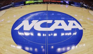 **FILE** In this March 21, 2013, file photo, in this image taken with a fisheye lens, the NCAA logo is displayed at mid-court before Albany&#39;s practice for a second-round game of the NCAA college basketball tournament in Philadelphia. (AP Photo/Matt Slocum, File)