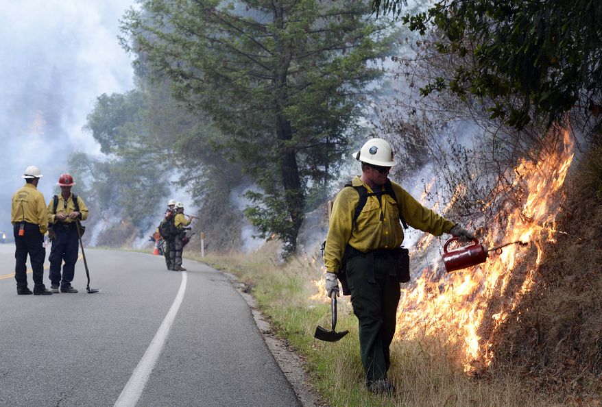 Firefighters light a backfire a backfire along Highway 1 between Pfeiffer Ridge Road and the Big Sur Station in Big Sur, Calif. on Wednesday Dec. 18, 2013. Calm winds helped crews as they closed in on fire in Los Padres National Forest near state Highway 1. The blaze had consumed 769 acres, or a little over a square mile, as the 20 percent containment figure officials gave earlier Wednesday was expected to climb. (AP Photo/ Monterey County Herald, David Royal)