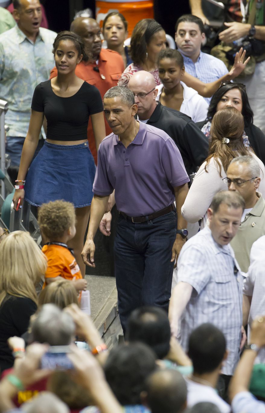 President Obama (center), and his daughter, Malia (left), arrive at the Stan Sheriff Center before the start of the Oregon State-Akron NCAA college basketball game at the Diamond Head Classic in Honolulu on Dec. 22, 2013. The President's brother-in-law Craig Robinson is the head coach of Oregon State. (Associated Press)