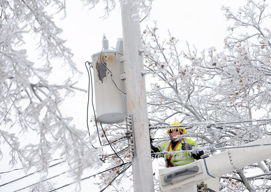 Dave Dora, a lineman from Grand Haven Board of Light and Power, works on connecting fallen wires on Macon Avenue in Lansing, Mich., Monday, Dec. 23, 2013. From Michigan to Maine, hundreds of thousands remain without power days after a massive ice storm _ which one utility called the largest Christmas-week storm in its history _ blacked out homes and businesses in the Great Lakes and Northeast. (AP Photo/Lansing State Journal, Greg DeRuiter)