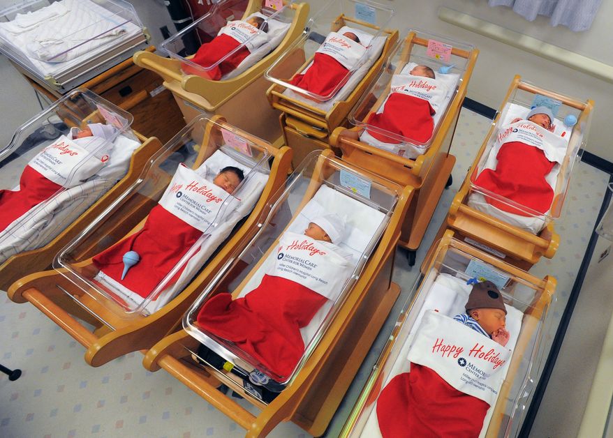 Newborns sleep in oversized red stockings in the nursery at Long Beach Memorial in Long Beach, Calif., on Monday, Dec. 23, 2013. For more than 50 years, babies born between Dec. 21-25 at Long Beach Memorial are placed in big red stockings to be presented to the new parents.(AP Photo/Daily Breeze, Scott Varley)
