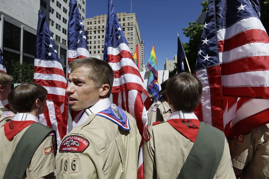 ** FILE ** In this June 30, 2013, file photo, Boy Scouts from the Chief Seattle Council carry U.S. flags as they prepare to march in the Gay Pride Parade in downtown Seattle. The Boy Scouts of America, in the most contentious change of membership policy in a 103-year history, will accept openly gay youths in Scout units starting on New Year's Day 2014. (AP Photo/Elaine Thompson, File)