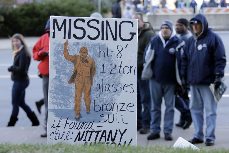 FILE - In this Nov. 23, 2013 file photo, college football fans pause at the sight outside Beaver Stadium where there once stood a bronze statue of long-time Penn State football coach Joe Paterno before an NCAA college football game between Penn State and Nebraska in State College, Pa. The Nittany Lions have had two years of modified success under coach Bill O'Brien, and as the program, school and town continue to push past the Jerry Sandusky scandal, the focus is clearly on moving forward in this new era as a community, as a team, and as Nittany Lions. (AP Photo/Gene J. Puskar, File)