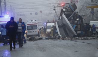 Ambulances line up a site of a trolleybus explosion, background, in Volgograd, Russia Monday, Dec. 30, 2013.  A bomb blast tore through the trolleybus in the city Volgograd on Monday morning, killing at least 10 people a day after a suicide bombing that killed at 17 at the city&amp;#8217;s main railway station. (AP Photo/Denis Tyrin)