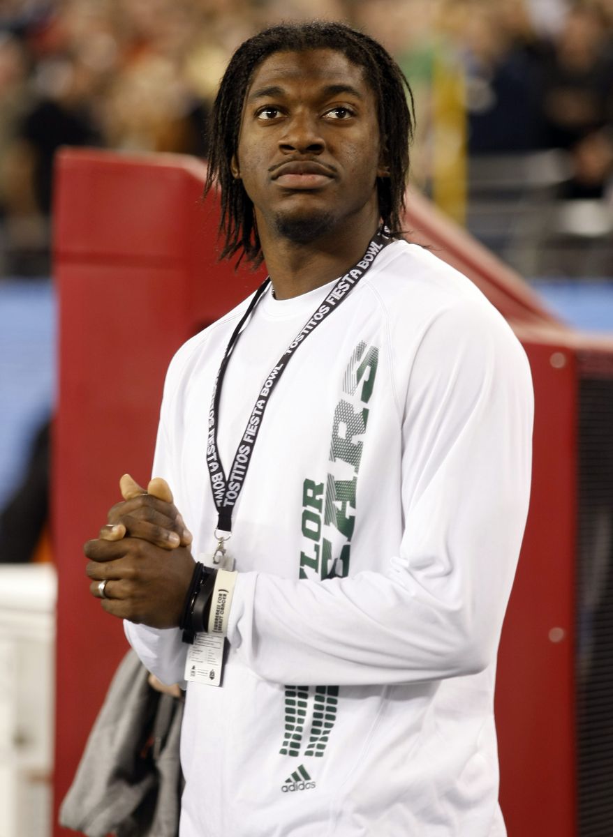 Washington Redskins quarterback Robert Griffin III watches Baylor and Central Florida play during the first half of the Fiesta Bowl NCAA college football game, Wednesday, Jan. 1, 2014, in Glendale, Ariz. (AP Photo/Rick Scuteri)