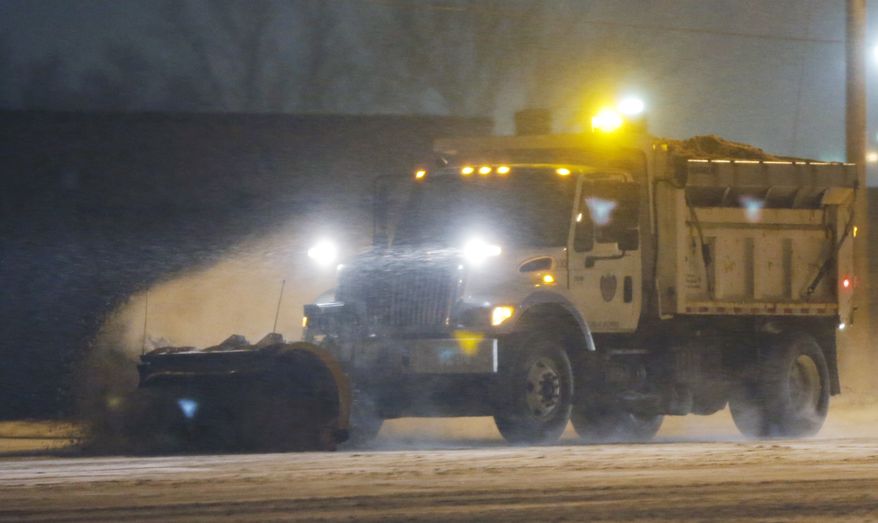 A city snow plow clears drifts of snow along U.S. 59 in Lawrence, Kan., Wednesday, Jan. 1, 2014. A winter weather advisory is in effect for the area. (AP Photo/Orlin Wagner)