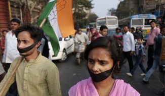 Activists of Indian National Congress with black bands around their mouth block traffic during a protest against a gang-rape and murder of a 16-year-old girl at Madhyamgram, about 25 kilometers (16 miles) north of Kolkata, India, Friday, Jan. 3, 2014. On Dec. 31 the girl set herself on fire and died due to burn injuries after being raped twice in October. The death of the girl has sparked outrage in the metropolis. (AP Photo/Bikas Das)