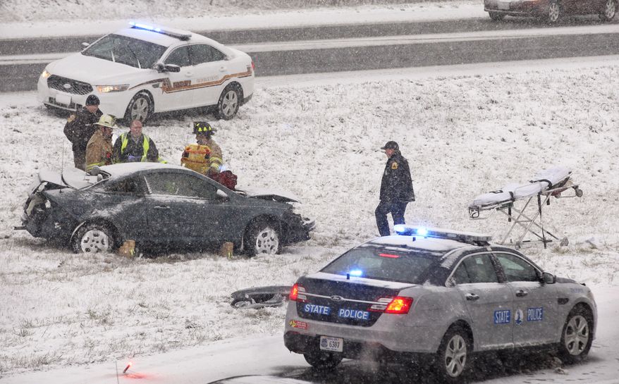 Law enforcement, fire and rescue workers prepare to remove an injured passenger from a car that was in an accident involving a tractor-trailer Thursday, Jan. 2, 2014, near Winchester,Va., as snow fell in the northern Shenandoah Valley. (AP Photo/The Winchester Star, Scott Mason)