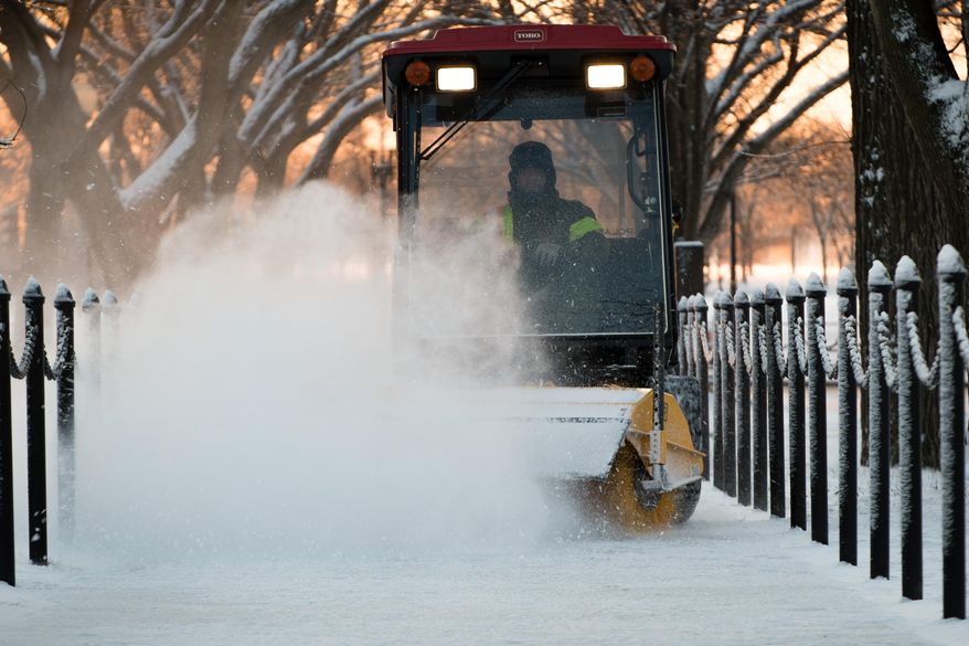 A park ranger brushes a light dusting of snow from an overnight storm from the sidewalks near the Lincoln Memorial in Washington early Friday morning Jan. 3, 2014. After a storm blew through the Washington region overnight, roads are being cleared and many schools systems are closed. The federal government and the District of Columbia government will be open Friday, but workers have the option to take leave or telework. (AP Photo/J. David Ake)