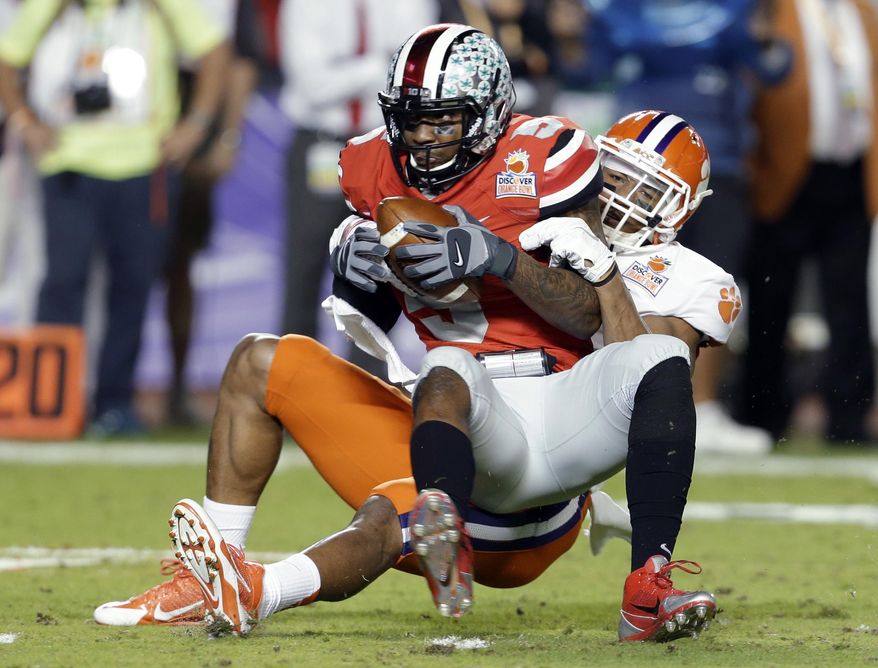 Ohio State quarterback Braxton Miller is brought down by Clemson defensive end Vic Beasley during the first half of the Orange Bowl NCAA college football game, Friday, Jan. 3, 2014, in Miami Gardens, Fla. (AP Photo/Lynne Sladky)