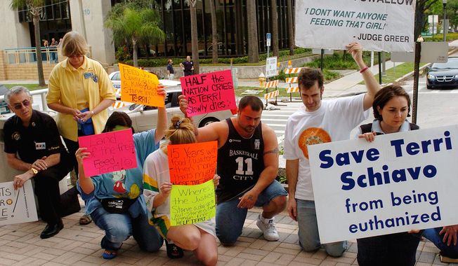 In this March 24, 2005, photo, demonstrators pray for Terri Schiavo outside the Pinellas County Courthouse in Clearwater, Fla. Schiavo, in a vegetive state, died after a seven-year legal fight by her husband to get her feeding tube removed. The legal fight prompted a national debate about the right to die. (AP Photo/Steve Nesius, File)