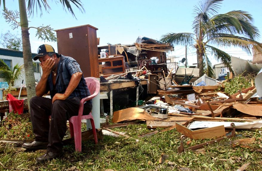 FILE - In this Aug. 15, 2004 file photo, Francisco Bernal sits in front of what used to be his home inside the Pink Citrus Mobile Home Park on Pine Island, Fla., after Hurricane Charley. Charley was one of several brutal hurricanes to have hit Florida the last decade, costing many lives, billions of dollars in damage and helping make homeowners insurance rates some of the most expensive nationwide. (AP Photo/Naples Daily News, Lexey Swall, File)