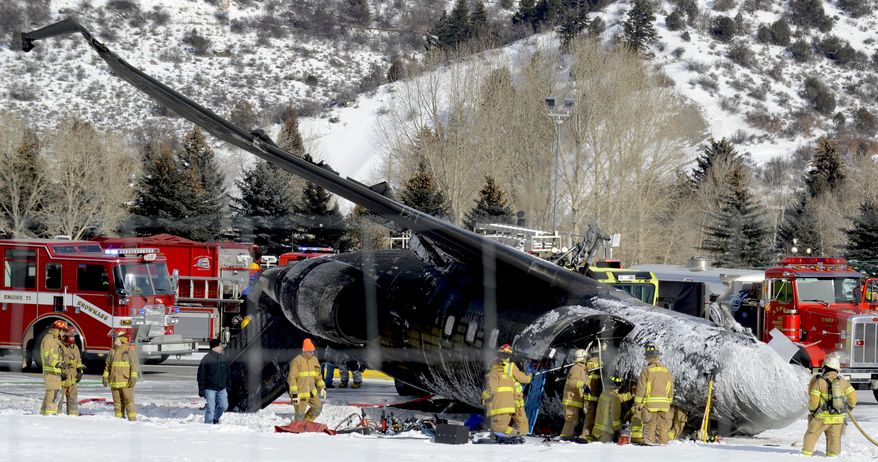 Emergency crews work near a passenger plane that crashed upon landing at the Aspen-Pitkin County Airport in Aspen, Colo., Sunday, Jan. 5, 2014. (AP Photo/The Aspen Times, Leigh Vogel)