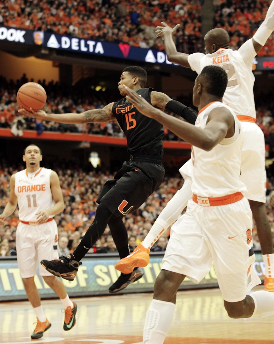 Miami’s Rion Brown, center, drives to the basket past Syracuse’s Tyler Ennis, left, Baye Moussa Keita, top, and Jerami Grant, right, during an NCAA college basketball game in Syracuse, N.Y., Saturday, Jan. 4, 2014. (AP Photo/Nick Lisi)