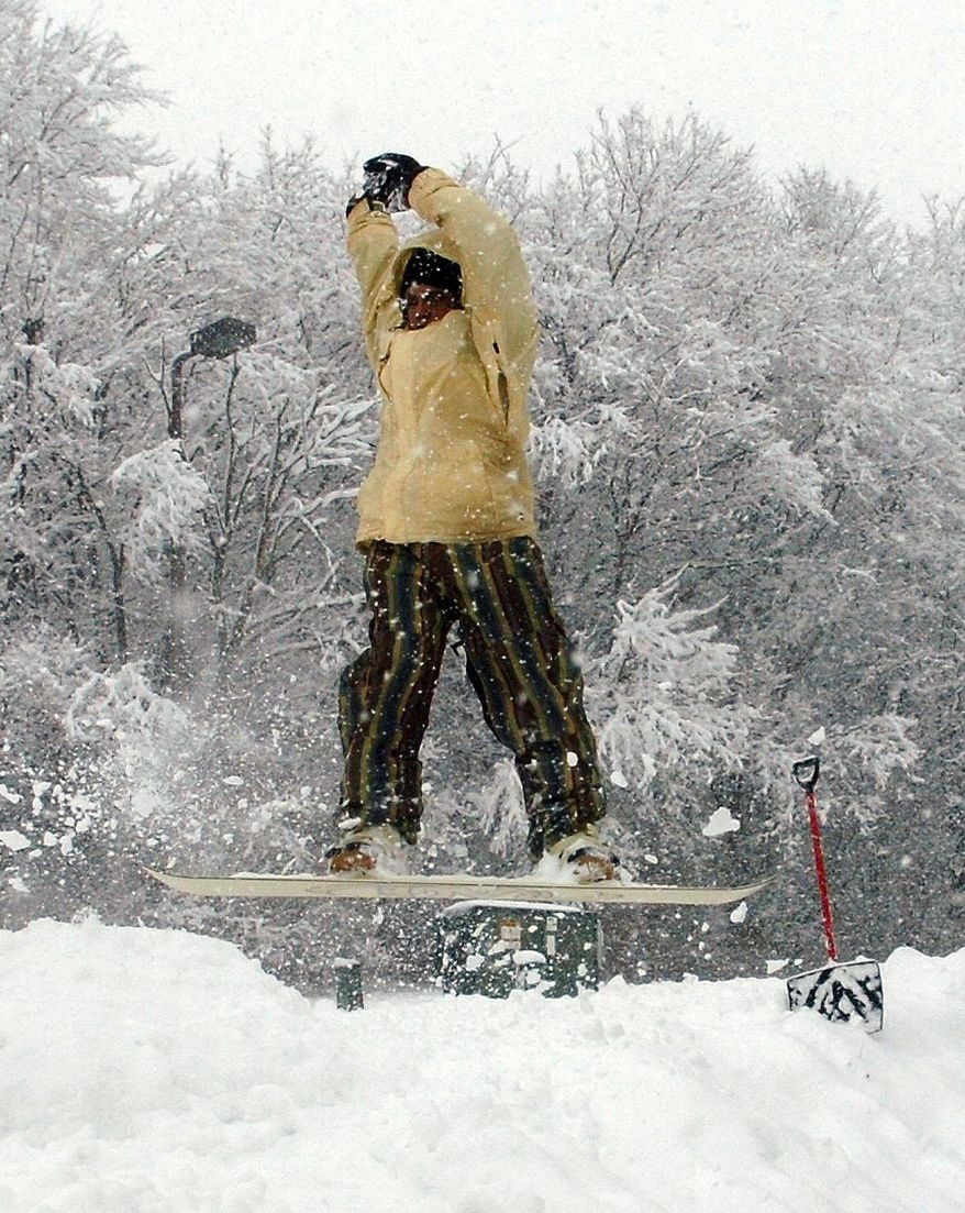 Greg Davis nails a 180-degree turn on a snow jump he build at Reservoir Park in Fort Wayne, Ind., Sunday, Jan 5, 2014. Several hours of light but steady snow brought out sledders and cautious drivers. (AP Photo/The Journal-Gazette, Samuel Hoffman) NEWS-SENTINEL OUT; MANDATORY CREDIT; NO SALES; MAGS OUT