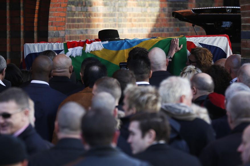 Mourners carry the coffin of great train robber Ronnie Biggs into the chapel at Golders Green Crematorium in London, Friday Jan. 3, 2014. Biggs was a member of a gang that stole 2.6 million pounds from a Glasgow-to-London mail train in August 1963, in what was called the "heist of the century." He spent decades in exile in Brazil before agreeing to return to Britain, and prison, in 2001. (AP Photo/Sang Tan)
