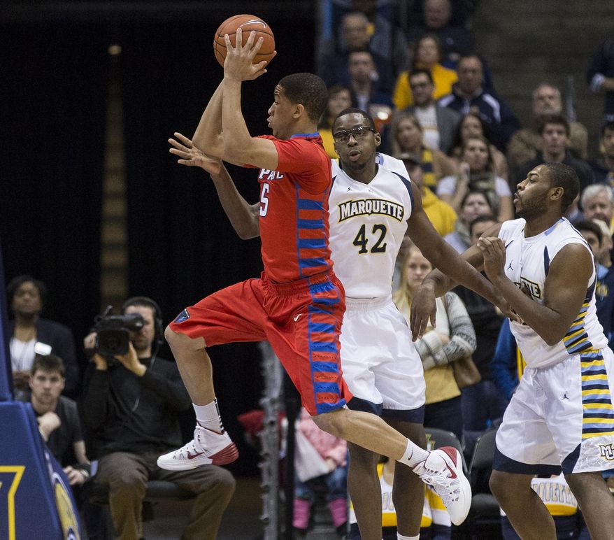 Marquette's Chris Otule (42) defends the hoop as DePaul's Billy Garrett Jr. looks to pass during the first half of an NCAA college basketball game Saturday, Jan. 4, 2014, in Milwaukee. (AP Photo/Tom Lynn)