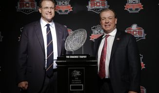 Auburn head coach Gus Malzahn, left, and Florida State head coach Jimbo Fisher pose with The Coaches&#39; Trophy during a news conference for the NCAA BCS National Championship college football game Sunday, Jan. 5, 2014, in Newport Beach, Calif. Florida State plays Auburn on Monday, Jan. 6, 2014. (AP Photo/David J. Phillip) 