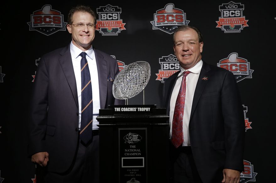 Auburn head coach Gus Malzahn, left, and Florida State head coach Jimbo Fisher pose with The Coaches' Trophy during a news conference for the NCAA BCS National Championship college football game Sunday, Jan. 5, 2014, in Newport Beach, Calif. Florida State plays Auburn on Monday, Jan. 6, 2014. (AP Photo/David J. Phillip)