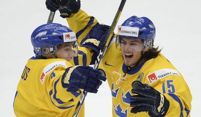 Sweden's Christian Djoos, left, celebrates his goal with teammate Sebastian Collberg during third-period gold medal game action at the IIHF World Junior Hockey Championship in Malmo, Sweden, Sunday, Jan. 5, 2014. (AP Photo/The Canadian Press, Frank Gunn)
