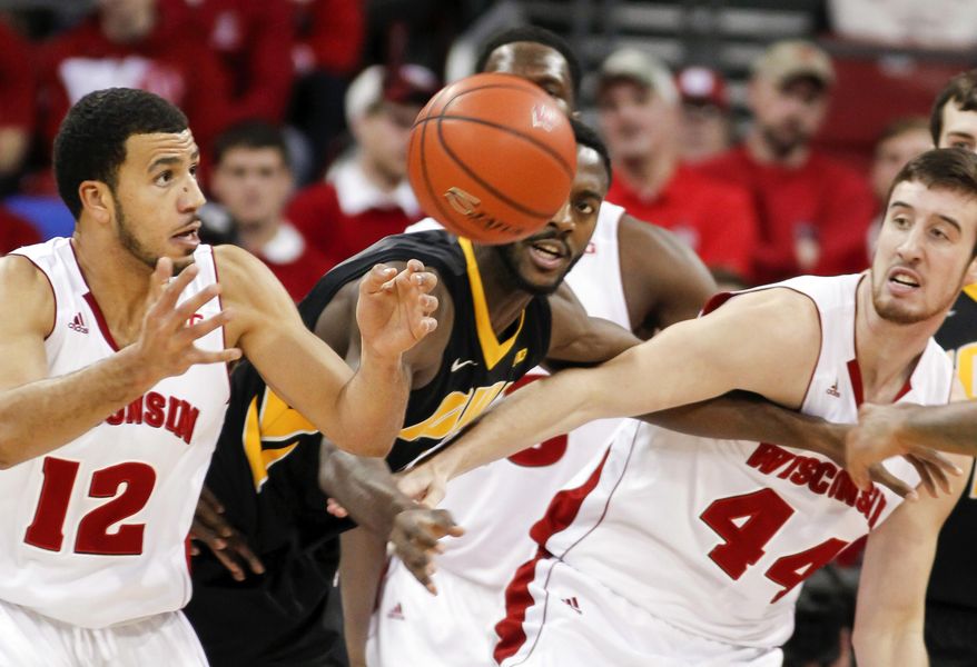 Wisconsin's Traevon Jackson, left, and Frank Kaminsky (44) go after a rebound against Iowa's Gabriel Olaseni during the first half of an NCAA college basketball game Sunday, Jan. 5, 2014, in Madison, Wis. (AP Photo/Andy Manis)
