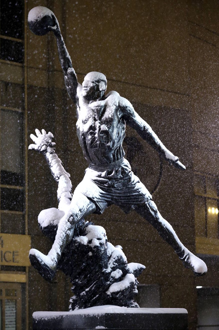 Michael Jordan statue is covered by snow outside of United Center in Chicago on Saturday, Jan. 4, 2014. The National Weather Service issued a winter storm warning that is in effect until 6 p.m. Sunday calling for moderate to heavy snow that will make for hazardous travel conditions. (AP Photo/Nam Y. Huh)