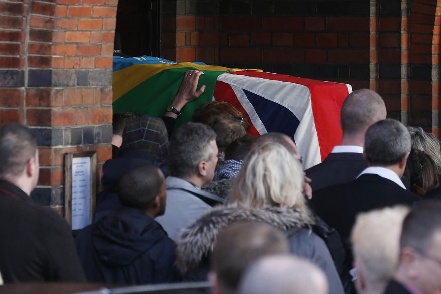 Mourners carry the coffin of great train robber Ronnie Biggs into the chapel at Golders Green Crematorium in London, Friday Jan. 3, 2014. Biggs was a member of a gang that stole 2.6 million pounds from a Glasgow-to-London mail train in August 1963, in what was called the "heist of the century." He spent decades in exile in Brazil before agreeing to return to Britain, and prison, in 2001. (AP Photo/Sang Tan)