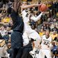Missouri&#39;s Jordan Clarkson, center, passes the ball around Long Beach State&#39;s David Samuels, left, as Jabari Brown, right, stands near during the first half of an NCAA college basketball game Saturday, Jan. 4, 2014, in Columbia, Mo. (AP Photo/L.G. Patterson)