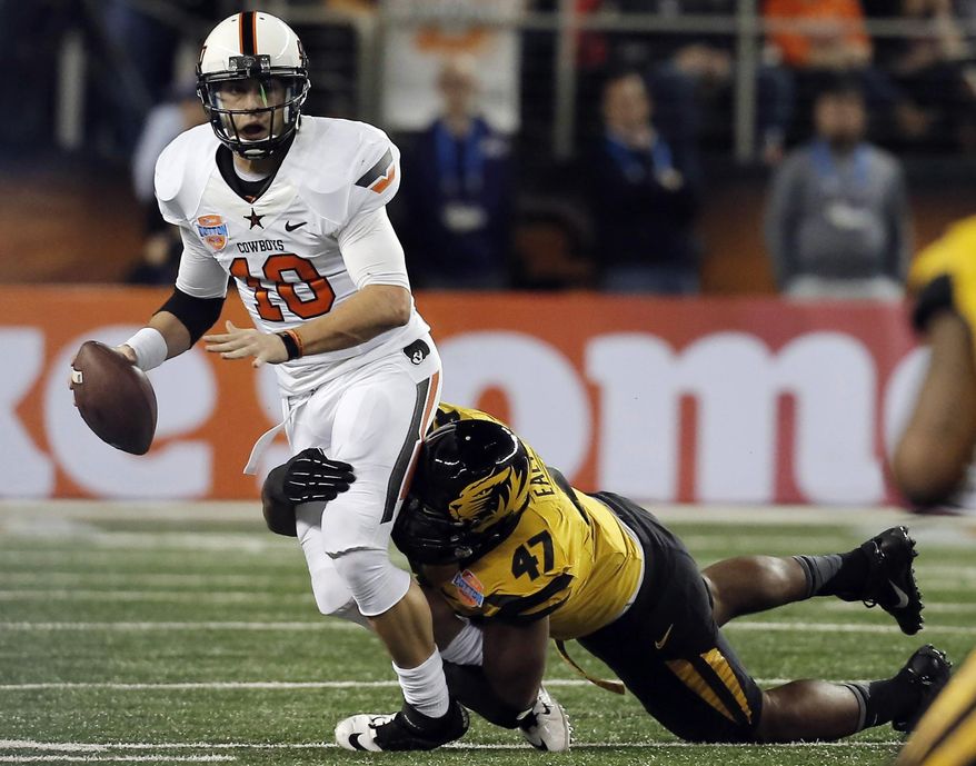 Missouri defensive lineman Kony Ealy (47) sacks Oklahoma State quarterback Clint Chelf (10) during the first half of the Cotton Bowl NCAA college football game on Friday, Jan. 3, 2014, in Arlington, Texas. (AP Photo/Brandon Wade)