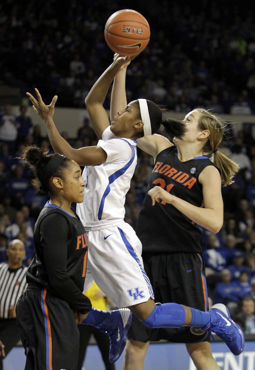 Kentucky's Janee Thompson, center, shoots between Florida's Cassie Peoples, left, and Lily Svete during the first half of an NCAA college basketball game, Sunday, Jan. 5, 2014, in Lexington, Ky. (AP Photo/James Crisp)