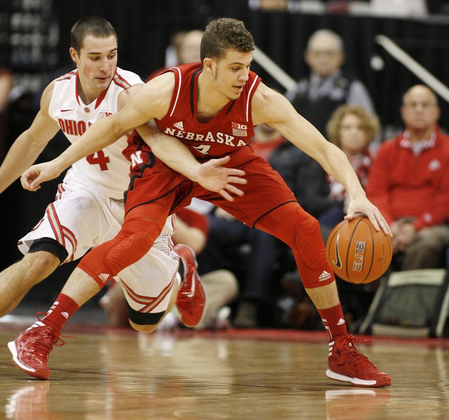 Ohio State's Aaron Craft (4) reaches for the ball against Nebraska's Nathan Hawkins (4) during the first half of an NCAA college basketball game Saturday, Jan. 4, 2014, in Columbus, Ohio. (AP Photo/Mike Munden)