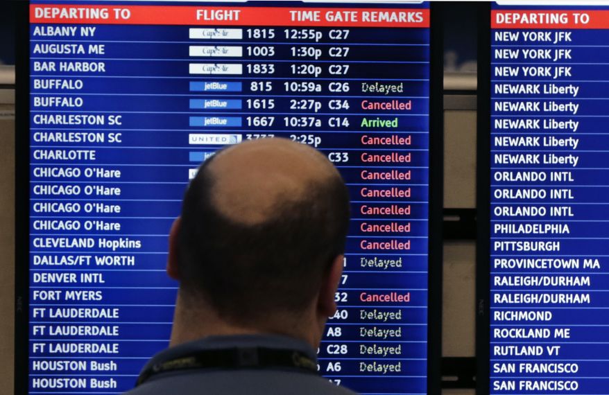 A man looks at a flight departure board filled with cancellations and delays at Logan Airport, Monday, Jan. 6, 2014, in Boston. Heavy rains in the East, and sub-zero temperatures in the Midwest, threw airlines and travel plans into havoc. (Associated Press)