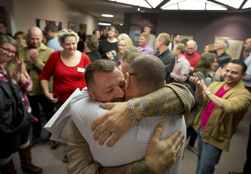 FILE - In this Dec. 20, 2013 file photo, Chris Serrano, left, and Clifton Webb embrace after being married, as people wait in line to get licenses outside of the marriage division of the Salt Lake County Clerk's Office in Salt Lake City. The Supreme Court on Monday, Jan. 6, 2014, put same-sex marriages on hold in Utah, at least while a federal appeals court more fully considers the issue. (AP Photo/Kim Raff, File)