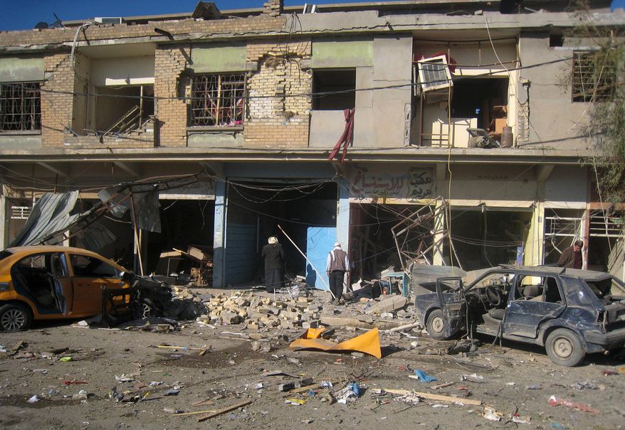 Civilians inspect the site of a car bomb attack in Kirkuk, 180 miles (290 kilometers) north of Baghdad, Iraq, Tuesday, Jan. 7, 2014. Police said a suicide bomber rammed his explosives-laden truck into a police station, killing and wounding scores of people in the northern city, home to a mix of Arabs, Kurds and Turkomen, each of the ethnic groups has competing claims to the oil-rich area. (AP Photo/Emad Matti)
