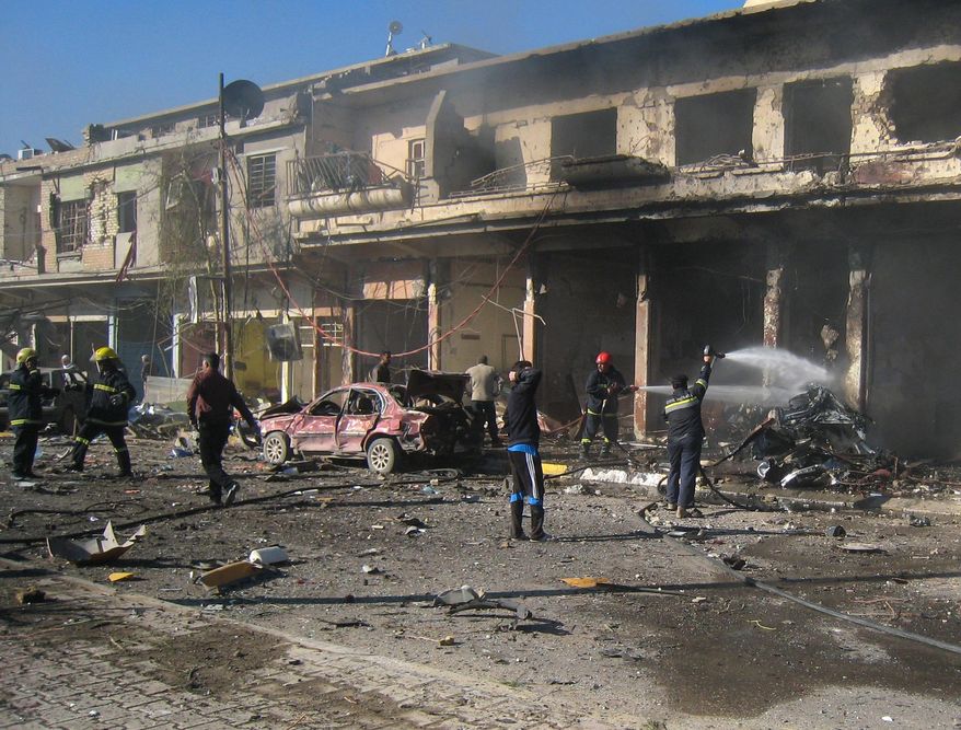 Iraqi firefighters hose down a burned car after a car bomb attack in Kirkuk, 180 miles (290 kilometers) north of Baghdad, Iraq, Tuesday, Jan. 7, 2014. Police said a suicide bomber rammed his explosives-laden truck into a police station, killing and wounding scores of people in the northern city, home to a mix of Arabs, Kurds and Turkomen, each of the ethnic groups has competing claims to the oil-rich area. (AP Photo/Emad Matti)