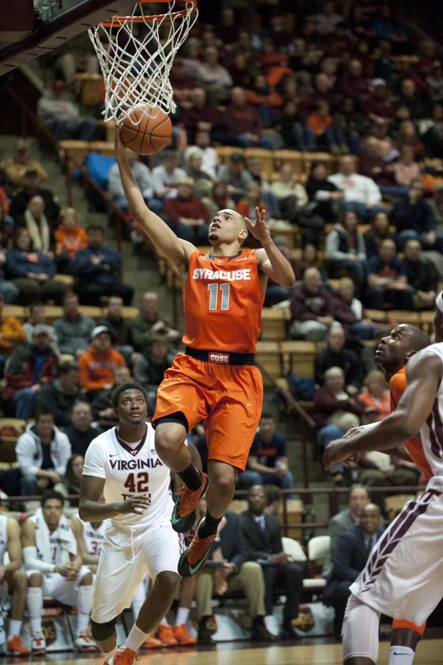 Syracuse's Tyler Ennis (11) goes up for a basket against Virginia Tech's C.J. Barksdale (42) during the first half of an NCAA college basketball game Tuesday, Jan. 7, 2014, in Blacksburg, Va. (AP Photo/Don Petersen)