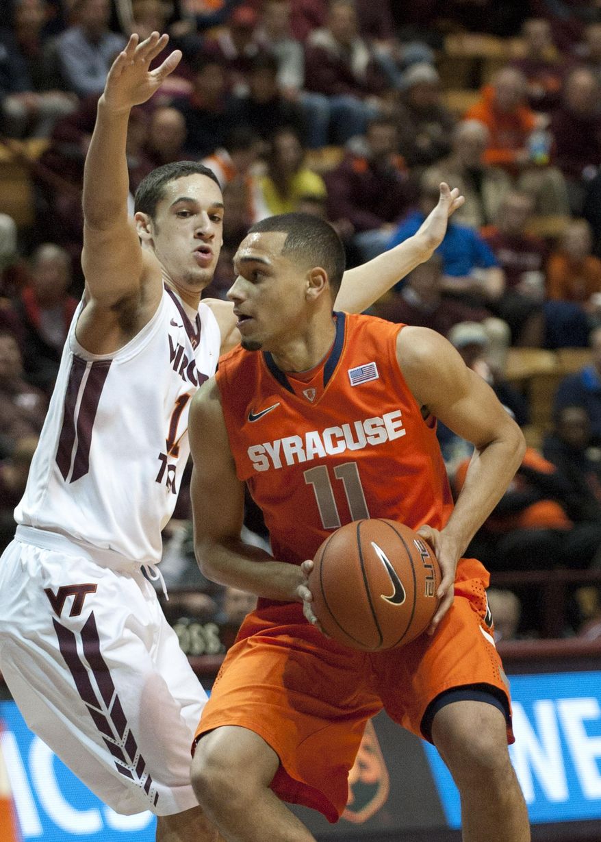 Syracuse's Tyler Ennis (11) looks to pass against Virginia Tech's Devin Wilson during the first half of an NCAA college basketball game Tuesday, Jan. 7, 2014, in Blacksburg, Va. (AP Photo/Don Petersen)